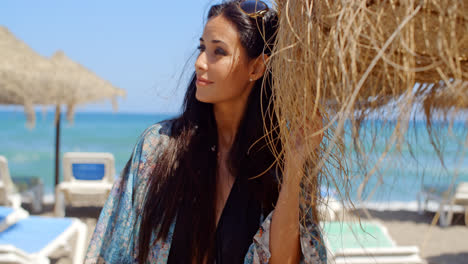 Woman-Holding-Beach-Umbrella-Looking-Into-Distance