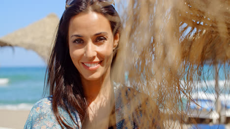 Smiling-Pretty-Young-Lady-Beside-a-Beach-Umbrella