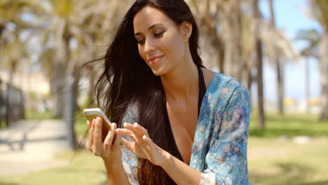 Pretty-Lady-in-Beach-Wear-Using-her-Mobile-Phone