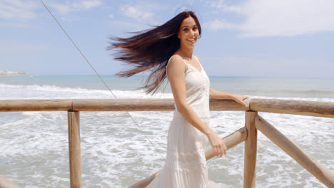 Señora-Sosteniendo-En-La-Barandilla-De-La-Playa-Con-El-Pelo-Soplado-Por-Aire