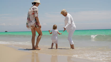 Niña-Disfrutando-En-La-Playa-Con-Mamá-Y-Abuela