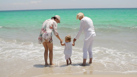 Abuela-Y-Mamá-Sosteniendo-A-Una-Niña-En-La-Playa