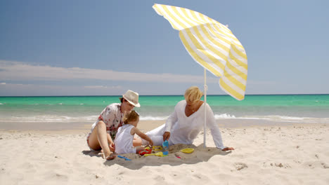 Abuela-Mamá-Y-Niña-Jugando-En-La-Arena-De-La-Playa