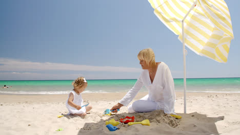 Kleines-Mädchen-Spielt-Mit-Ihrer-Oma-Am-Strand