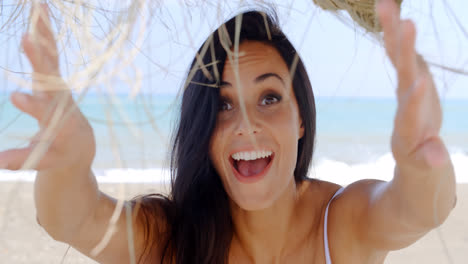 Mujer-Despreocupada-Sonriendo-A-La-Cámara-En-La-Playa-Tropical