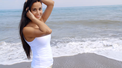 Mujer-Caminando-Por-La-Playa-Y-Sonriendo-A-La-Cámara