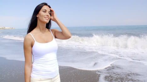 Woman-Walking-on-Beach-and-Smiling-at-Camera