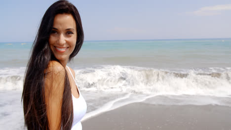 Mujer-Morena-En-La-Playa-Sonriendo-Sobre-El-Hombro