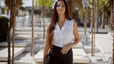 Young-businesswoman-walking-through-a-park