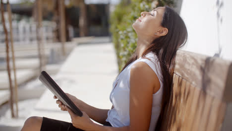 Joven-Empresaria-Relajándose-En-Un-Banco-Al-Aire-Libre