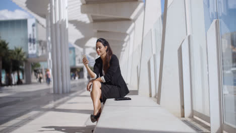 Elegant-businesswoman-checking-her-phone-messages