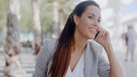 Woman-leaning-on-a-wall-chatting-on-a-mobile