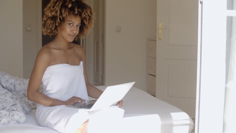 Junge-Frau-Mit-Laptop-Auf-Dem-Bett