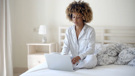 Junge-Frau-Mit-Laptop-Auf-Dem-Bett