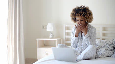 Young-Woman-Using-Laptop-On-Bed