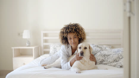 Frau-Hält-Einen-Hund-Auf-Einem-Bett