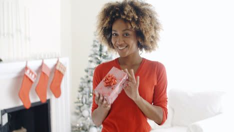 Mujer-Africana-Sonriente-Sosteniendo-Un-Regalo-De-Navidad