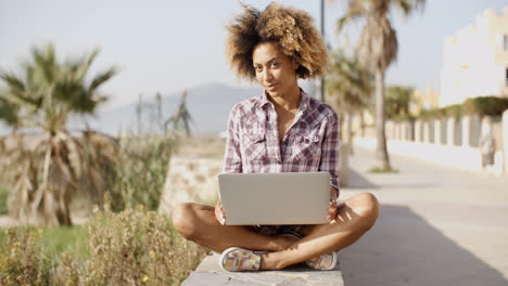 Girl-Browsing-A-Laptop-In-A-Bench