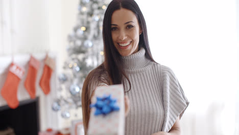 Mujer-Joven-Sonriente-Sosteniendo-Un-Regalo-De-Navidad