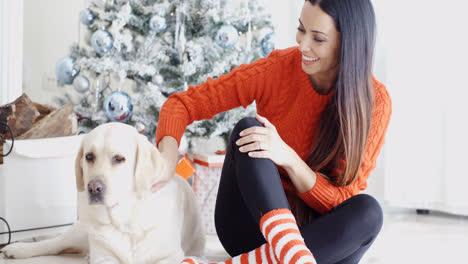 Lachende-Junge-Frau-Mit-Ihrem-Hund-Zu-Weihnachten