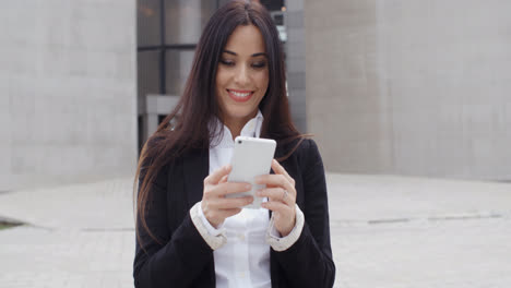 Attractive-businesswoman-checking-her-mobile-teléfono