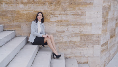 Serious-woman-sitting-on-stairs-outdoors