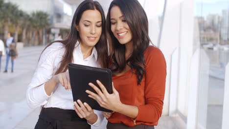 Two-Elegant-Dressed-Business-Women-Talking