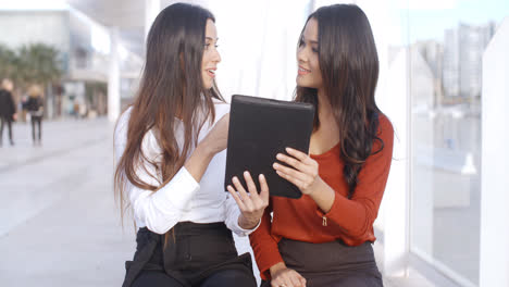 Two-women-discussing-information-on-a-tablet