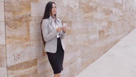 Female-worker-texting-and-leaning-against-wall