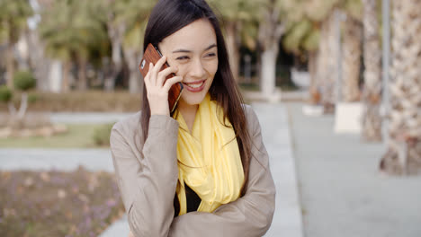 Mujer-Joven-De-Pie-Hablando-Por-Su-Teléfono-Móvil