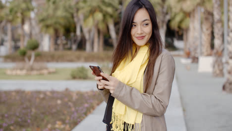 Mujer-Joven-Feliz-Enviando-Un-Mensaje-De-Texto