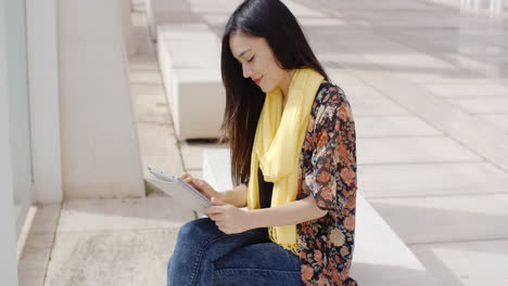 Junge-Frau-Sitzt-und-Liest-Ihr-Tablet