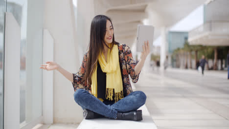 Mujer-Sonriente-Saludando-A-Su-Tableta