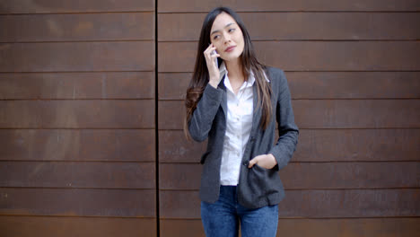 Mujer-Joven-Informal-Y-Relajada-Hablando-Por-Un-Móvil