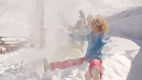 Young-couple-playing-in-the-snow-at-a-ski-resort