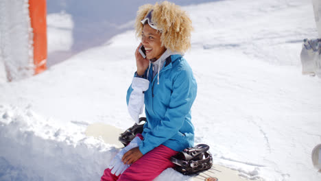 Lachende-Frau-Chattet-Auf-Ihrem-Handy-Im-Schnee