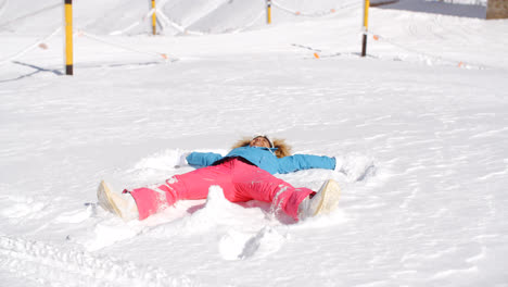 Junge-Frau-Macht-Einen-Schneeengel-Im-Weißen-Schnee