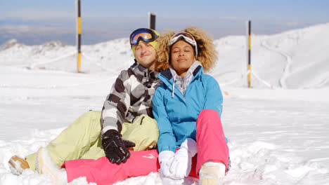 Pareja-Sentada-En-La-Nieve-En-La-Pista-De-Esquí