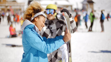 Man-flirting-with-woman-holding-snowboard