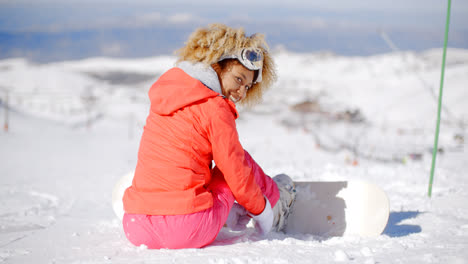 Woman-putting-a-snowboard-on-her-boots