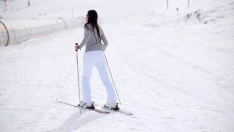 Cute-woman-on-skis-at-bottom-of-hill