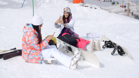 Jóvenes-Amigas-Relajándose-Con-Tablas-De-Snowboard