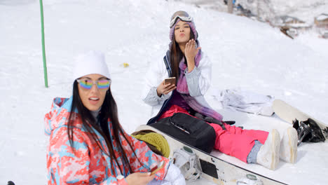 Two-attractive-women-snowboarders-relaxing