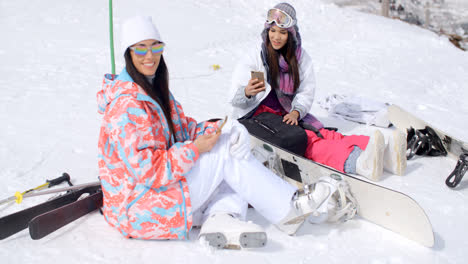 Dos-Mujeres-Atractivas-Practicantes-De-Snowboard-Relajándose