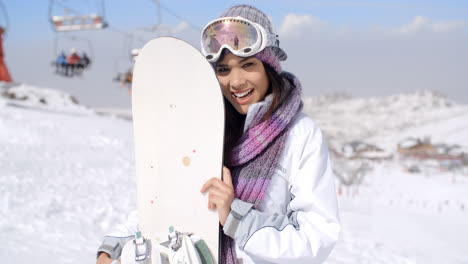 Laughing-young-woman-with-her-snowboard