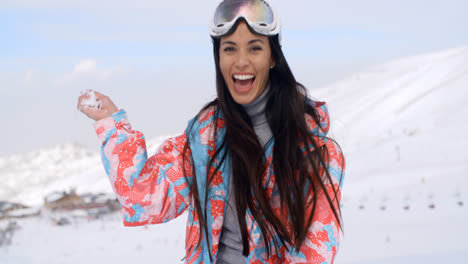 Mujer-Joven-Riendo-Lanzando-Una-Bola-De-Nieve