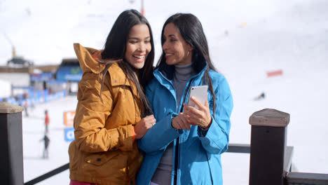 Dos-Mujeres-Jóvenes-Sonrientes-Revisando-Un-Teléfono