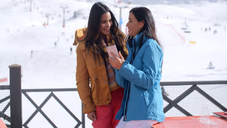 Dos-Mujeres-Jóvenes-Sonrientes-Revisando-Un-Teléfono