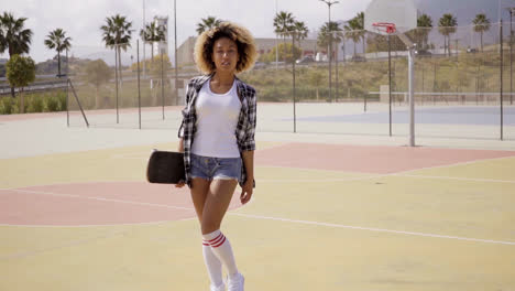 Mujer-Joven-Con-Patineta-Posa-Por-Cancha-De-Pelota