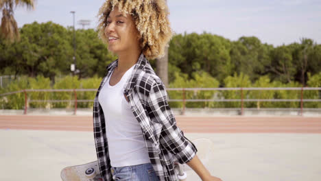 Una-Joven-Patinadora-Caminando-Con-La-Tabla-En-La-Mano.